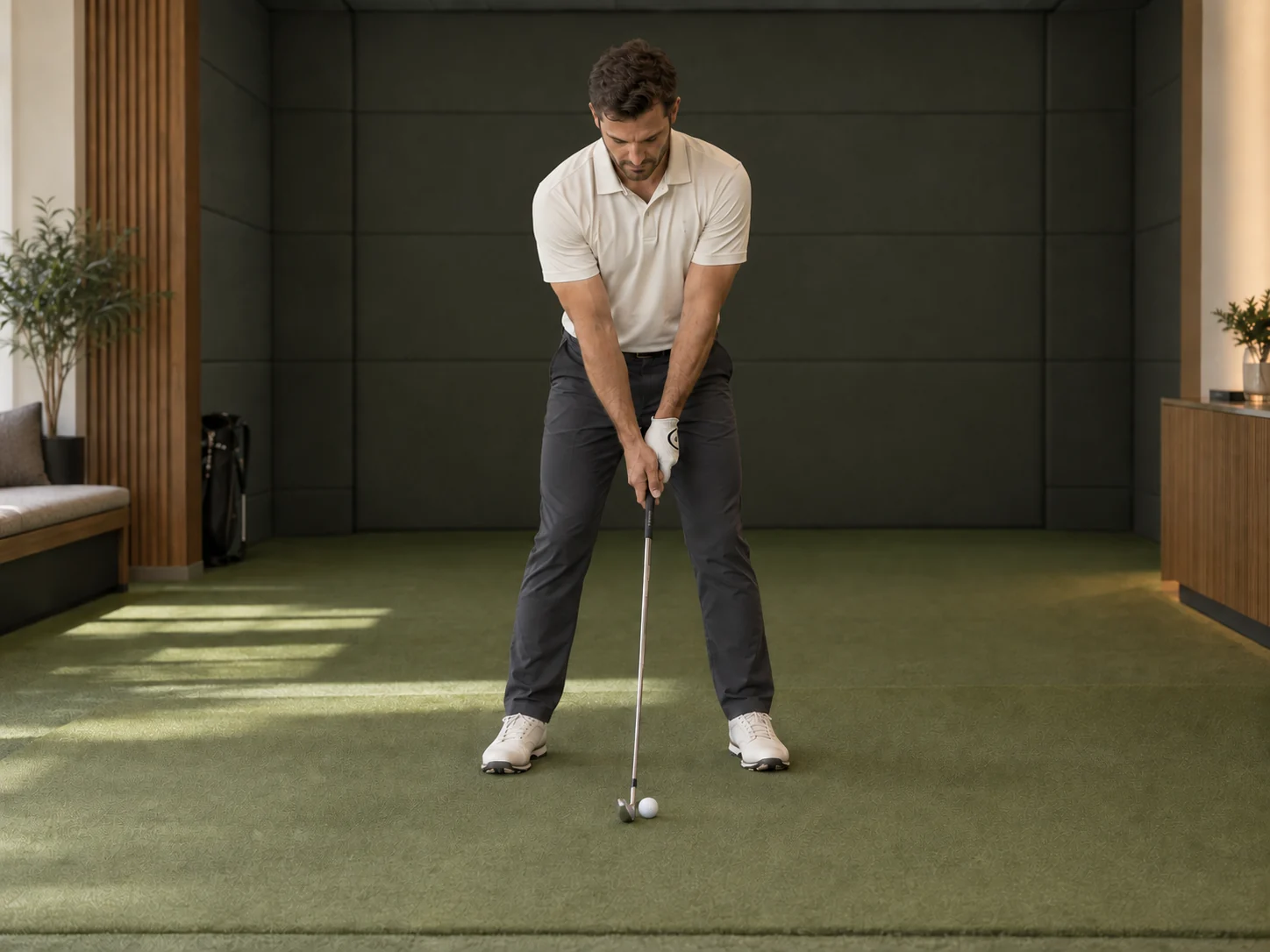 Illustrative face-on view of a golfer at address, with the entire body and club visible in an indoor bay.